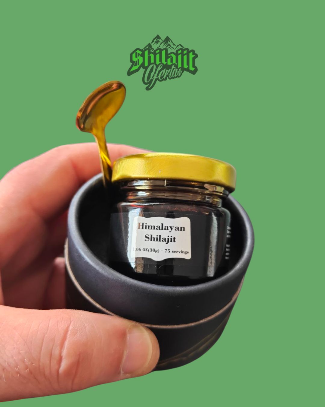 Mano sosteniendo un frasco de Shilajit del Himalaya con una cuchara y tapa doradas, presentado en un recipiente decorativo.